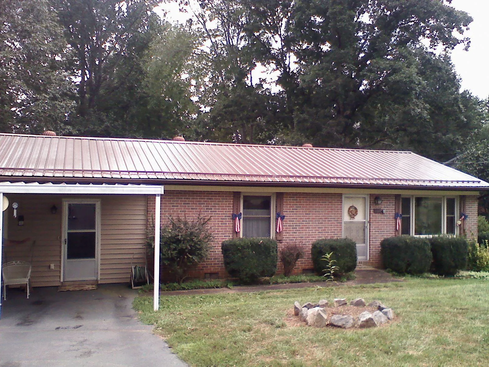 Bronze metal roof and carport on a brick ranch home — Roof Repair work by our crew in Mount Ayr